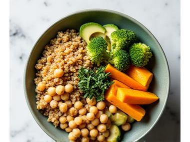 A colorful and hearty quinoa power bowl topped with roasted vegetables, avocado, and a light dressing, representing a quick and nutrient-dense gut-friendly meal.
